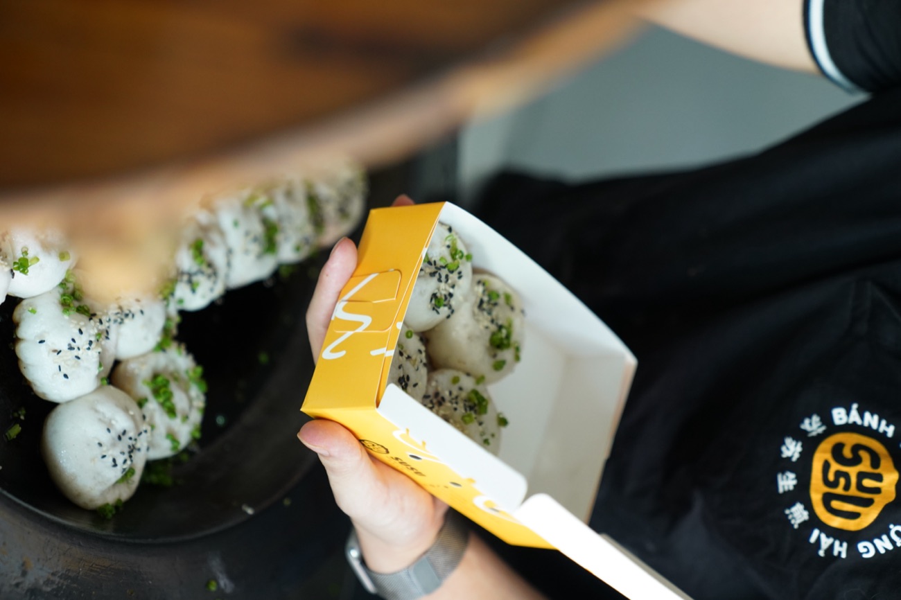 Gắp bánh vào hộp SuSuBao mang đi